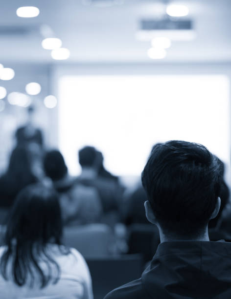 Speaker addressing group. Businessman entrepreneur giving a lecture to a sold-out crowd in a lecture hall. Speaker talking in seminar. Speaker at business conference or presentation stock photo. Male CEO talking during a business presentation in a board room. Copy space. Business coach concept. Seminar photo. Public speaking photo. Speaker photo. Presenter photo. Speaker talking in seminar with audience at business meeting for key of success stock photo. Business seminar photo. Confident male leader, coach talking with group of office workers picture. Presenter giving presentation to group of business people including investors and entrepreneurs. Successful businessman giving speech to audience picture. Workshop image with conference audience. Corporate seminar for tech entrepreneurs in auditorium. Audience participants in development workshop. Executive manager giving speech at symposium. Business training at university lecture hall.
Businessman entrepreneur giving a lecture to a sold-out crowd in a lecture hall. Speaker talking in seminar. Speaker image at business conference or presentation stock photo. Successful young entrepreneur giving speech.